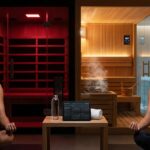 Split scene showing a modern infrared sauna with glowing red panels and an athlete wearing a heart rate monitor opposite a traditional wooden Finnish sauna with steam a bucket and a cold plunge tub visible nearby